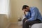 Mournful man sitting head in hands on his bed