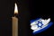 mourning candle burning front of flag Israel, memory of heroes served country, grief over loss, national unity in challenging