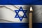 mourning candle burning front of flag Israel, memory of heroes served country, grief over loss, national unity in challenging