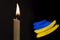 mourning candle burning front of flag Ukraine, memory of heroes served country, grief over loss, national unity in challenging