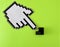 the mouse cursor hand from above points to the black enter button from the keyboard. green background