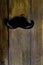 moustache symbol on wooden texture