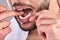 Mouth, dental and man floss teeth in studio  on a background for healthy hygiene. Tooth, flossing product and
