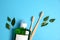 Mouthwash, two wooden bamboo eco friendly toothbrushes, green leaf on blue background. Teeth hygiene concept.