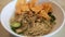 A mouthwatering bowl of Mie Ayam, a popular Indonesian dish yellow wheat noodles with diced chicken, mushrooms, and an array of