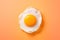 Mouthwatering fried egg with golden yolk isolated on yellow background, top down view