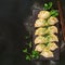 Mouthwatering presentation cabbage dumplings on dark background from above