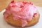 Mouthwatering strawberry-glazed with raspberry cream filling doughnut