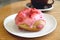 Mouthwatering strawberry-glazed with raspberry cream filling doughnut on a white plate