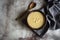 Mouthwatering sweet corn porridge in stylish wooden bowl with beautiful wooden spoon on vintage grey background