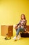 Move. Woman drinking coffee sitting on a tool box. Studio