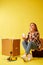 Move. Woman drinking coffee sitting on a tool box. Studio