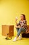 Move. Woman drinking coffee sitting on a tool box. Studio