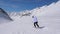 In Movement Back View, Woman Skier Skiing Down The Slope Of The Mountain On Skis