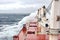 Movement of the vessel in stormy weather, Pacific Ocean. Waves and spray covering the ship during a storm