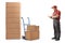 Mover standing next to a hand truck and a stack of boxes writing