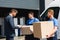 Movers with boxes standing near businessman
