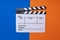 Movie clapper on blue and orange color table background ; film, cinema and video photography concept