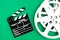 Movie clapper board and reel green background