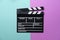 Movie clapper on green and pink table background ; film, cinema and video photography concept