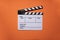 Movie clapper on orange table background ; film, cinema and video photography concept