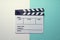 Movie clapper on white and green table background ; film, cinema and video photography concept