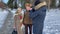 Movie maker walking with elderly couple and make a video. Romantic senior couple walkink in the park in winter time