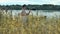 Movie producer in hair net stand out reed on lake shore and yell into speaker