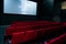 Movie screen and red chairs inside of a cinema