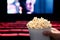 Movies and popcorn. Man holding pop corn box at cinema. Action, thriller or scifi entertainment on screen.