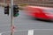 Moving blurred red car with green traffic light pole