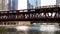 Moving brown line elevated el train, part of Chicago`s iconic transit system, passing over Chicago River at Wells Street