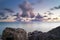 Moving clouds above large lake with smooth water and a sunset view from the coast