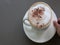 Moving coffee cappuccino froth latte drink cinnamon topping hand holding white mug on plate cinemagraph