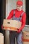 Moving or delivery service. Mover worker carrying cardboard boxes into home