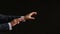 The moving hands of an orchestra conductor directing the musicians. Close-up shot. Black background