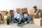 Moving and real estate concept. Black couple with cardboard boxes with smiley faces on head, sitting on floor