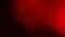 Moving red defocused lights through dark background.