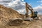 Moving stone and rock in the construction of a road by a large yellow excavator