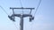 Moving up on cable car, funicular. Close up view of ski lift mechanism on top of support pillar isolated on blue sky on a sunny da