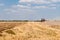 Mowing field, tractor, blue sky and clouds