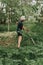 mowing the grass traditional old-fashioned way with the hand scythe on the household village farm