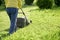 Mowing the lawn with an electric lawn mower at countryside