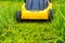 Mowing lawn green grass with an electric lawnmower