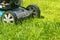 Mowing lawns, Lawn mower on green grass, mower grass equipment, mowing gardener care work tool, close up view, sunny day