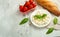 Mozzarella with basil leaves - fresh ingredients for Bruschetta, with cherry tomatoes and French baguette with copy space on a lig