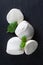 Mozzarella cheese with basil on black table top view. Natural italian dairy product