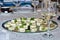 Mozzarella slices and green basil platter and white wine glasses