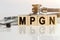 MPGN the word on wooden cubes, cubes stand on a reflective white surface, on cubes - a stethoscope