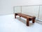 mpty brown long thick wooden bench seat on a white wall near the glass partition decoration inside the modern building.